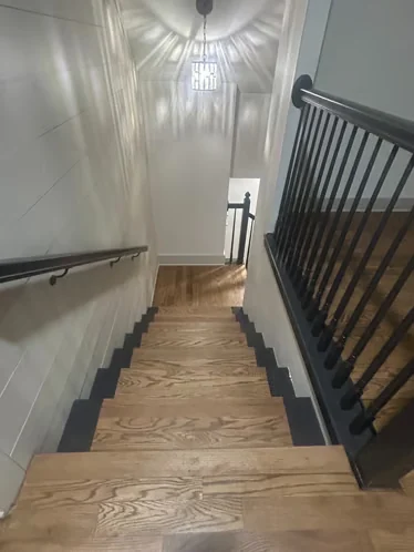 Stair landing with wood treads and black metal railing