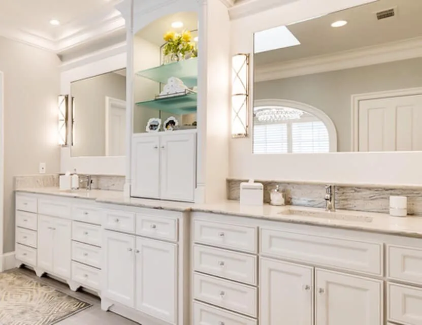 Custom white double vanity with full-width mirrors and illuminated niches
