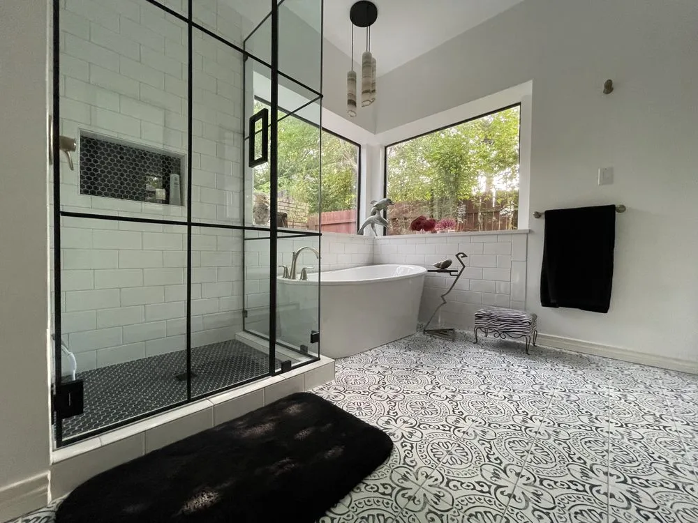Freestanding tub beside a black-frame walk-in shower