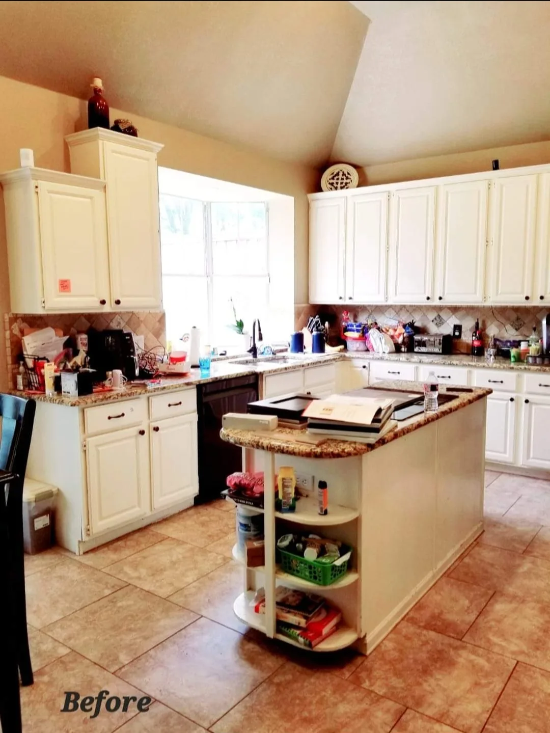 Before: the same kitchen's original dated cabinetry and granite counters