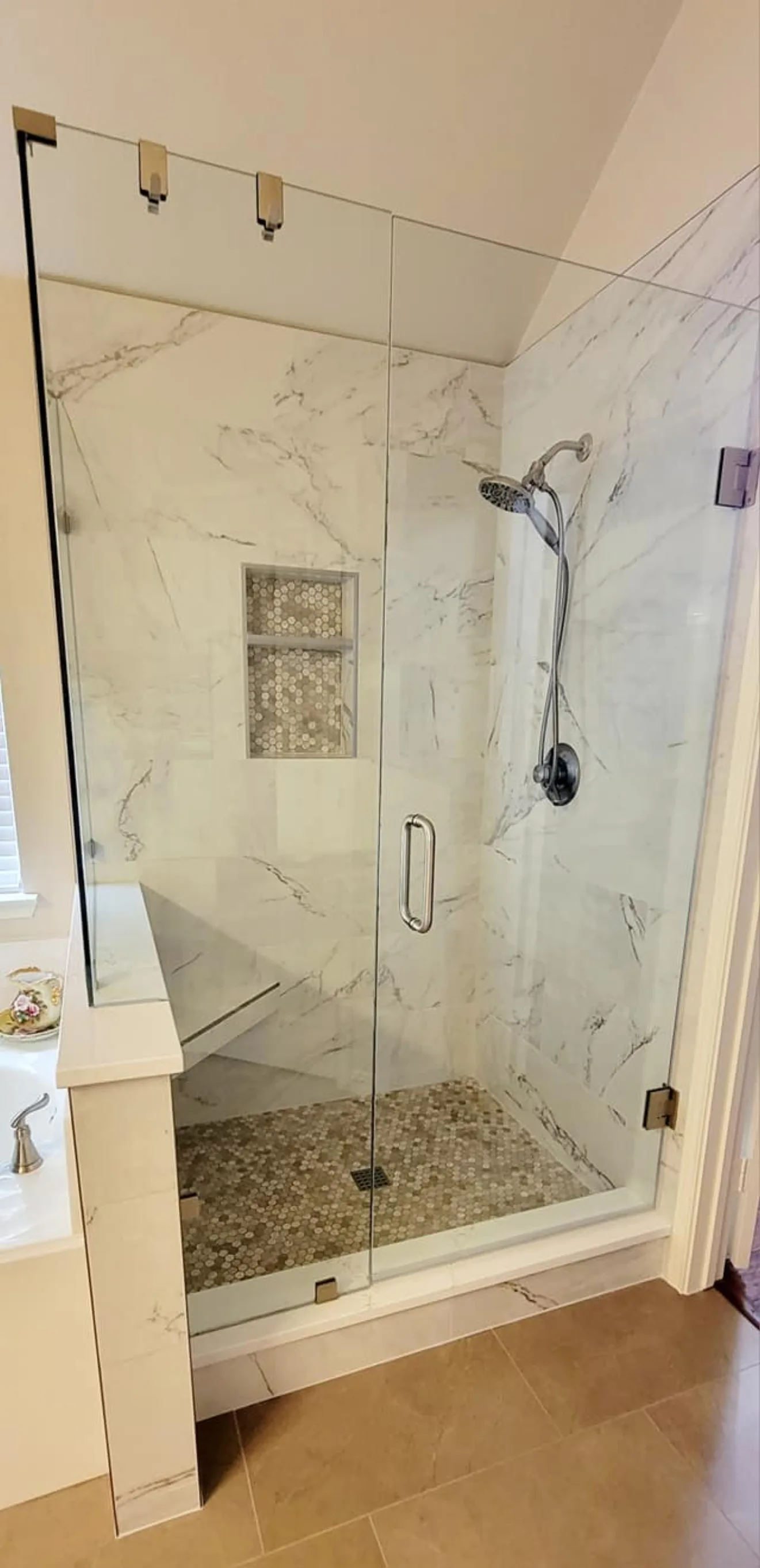Plano bathroom remodel: glass shower with marble tile and mosaic niche