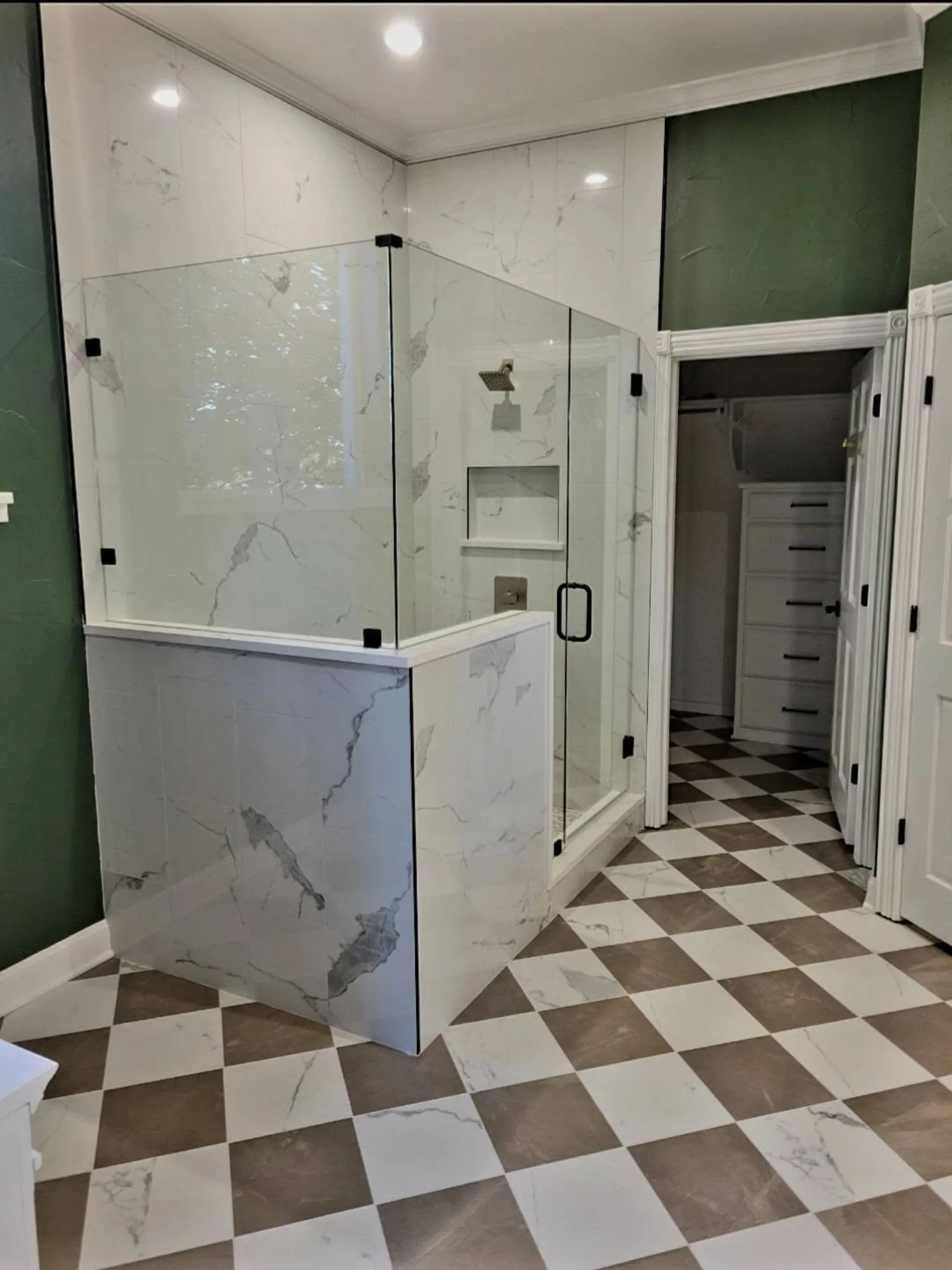Frameless corner glass shower with full-height marble tile surround